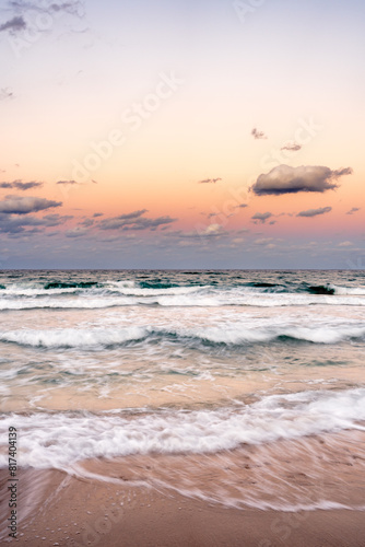 sunset over ocean with waves crashing on beach