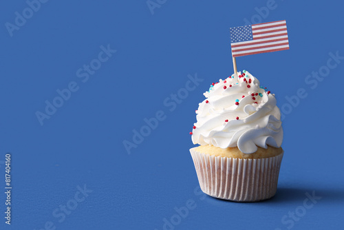 Foto Tasty patriotic cupcake with USA flag on blue background
