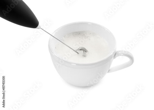 Whisking milk in cup with mini mixer  frother wand  isolated on white
