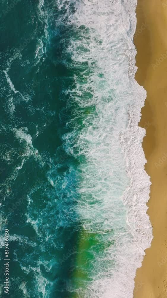 Vertical Screen: An Aerial Perspective Highlights The Intense Clash Of White Foamy Waves Against The Pristine Sandy Shore, Creating A Vivid Contrast. 4K Footage. Vertical Screen: An Aerial Perspective Highlights The Intense Clash Of White Foamy Waves Against The Pristine Sandy Shore, Creating A Vivid Contrast. 4K Footage.