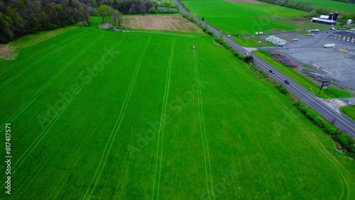 Tractor fertilizing a bright green field in Milesburg, PA, USA photo