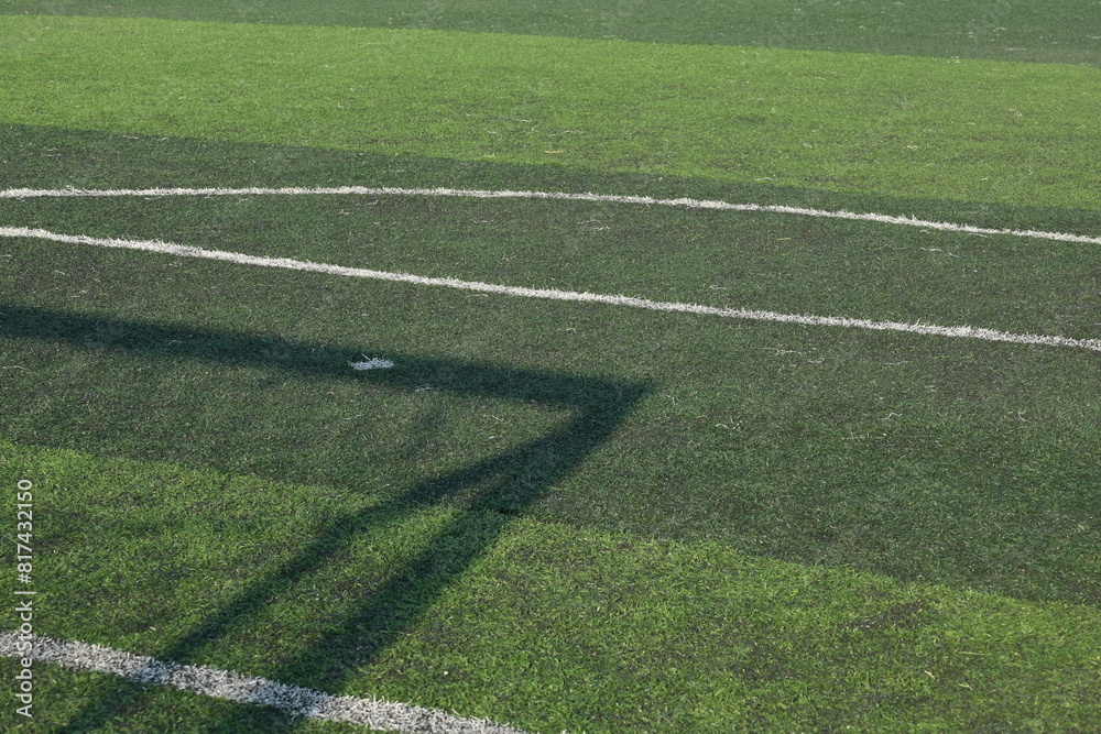 artificial green grass turf sport soccer field with black rubber granules infill and shadow of