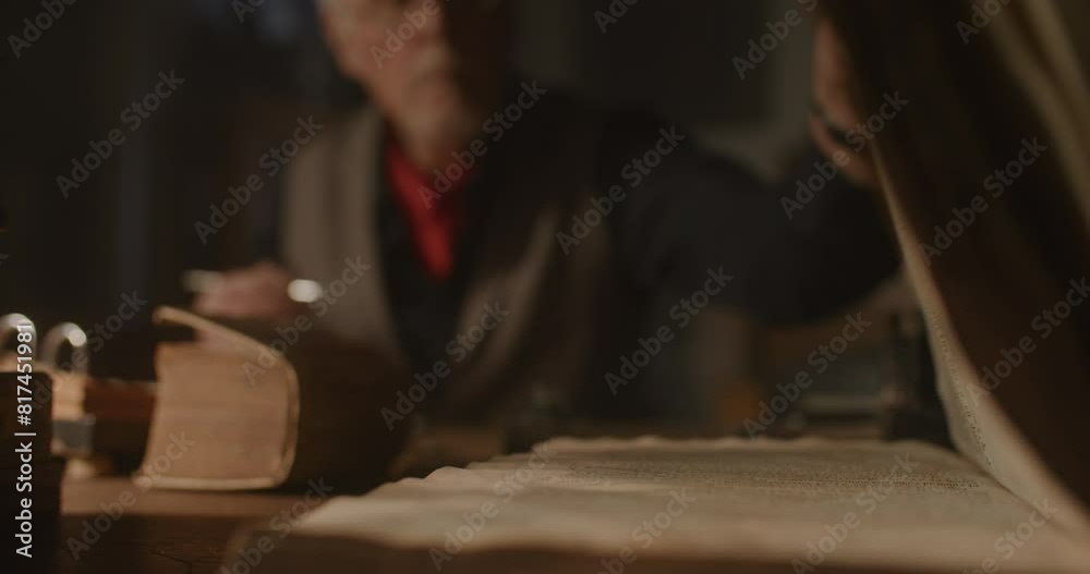 Old man picking something up from his desk.