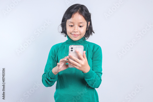 Smiling Little Girl Playing Games Using Smart Phone Isolated Grey Background