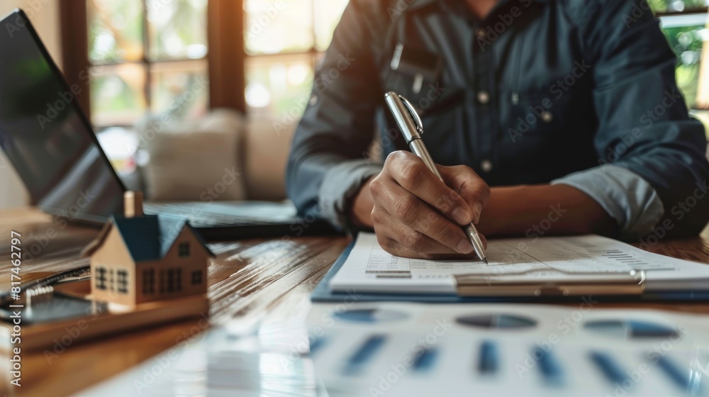A man is writing on a piece of paper in front of a house. A man is writing on a piece of paper in front of a house.