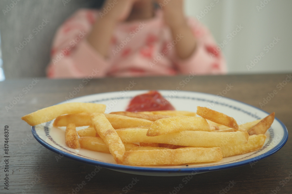 child eating french fries sitting on a chair child eating french fries sitting on a chair