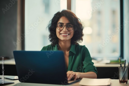 business woman, smile and working on laptop in office or company looking happy and satisfied. portrait of brazilian female worker or employee typing email on computer and planning strategy for vision