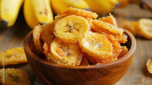 Crispy fried sliced banana with sugar sweet banana chips in wooden bowl