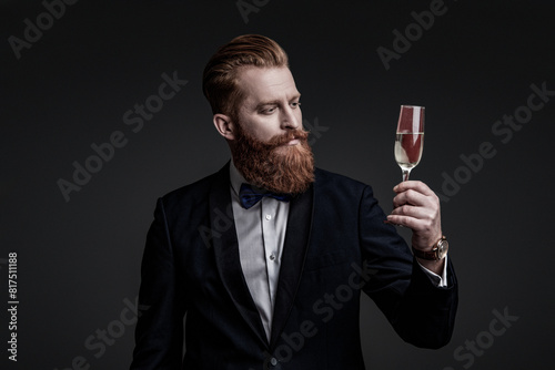 Celebrating success. Cheers. Bearded man with formal look. Celebrate with champagne. Cheering and celebrating. Elegant tuxedo man hold glass of champagne isolated on black. Sommelier