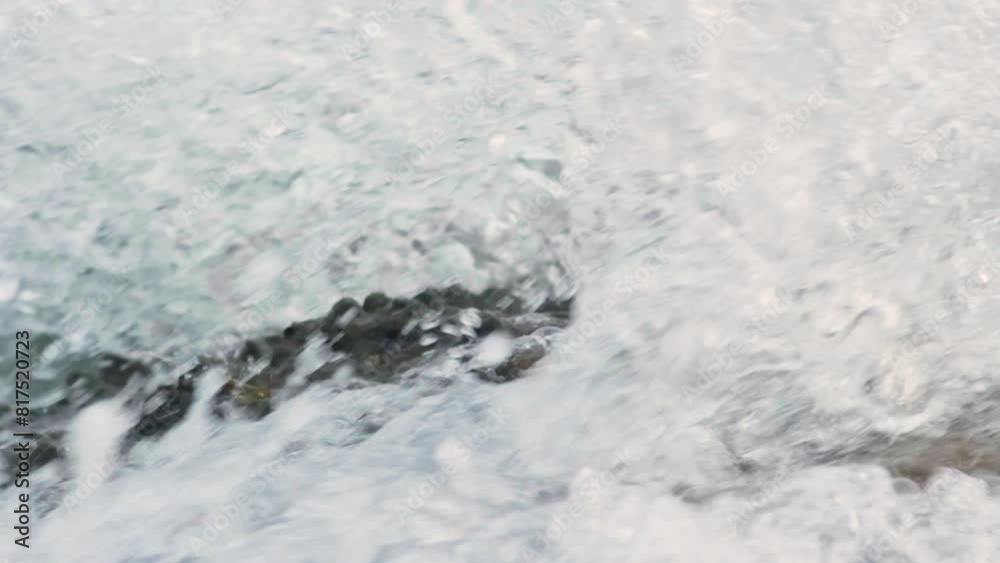 Slow motion video of wave crushing stone on a sea shore. Slow motion video of wave crushing stone on a sea shore.