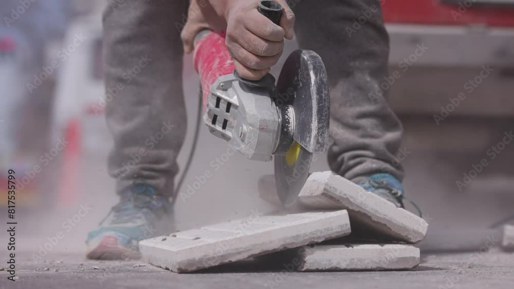 Trabajador corta una baldosa con una amoladora o radial. Herramienta de corte, Construcción y refacción. 