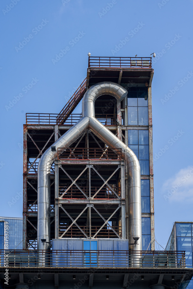 An industrial facility is built on the roof of a modern building with glass curtain walls An industrial facility is built on the roof of a modern building with glass curtain walls