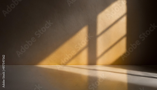 Abstract pastel yellow studio background for product presentation with shadow and light from windows.