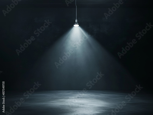 Single spotlight shining down in a dark room