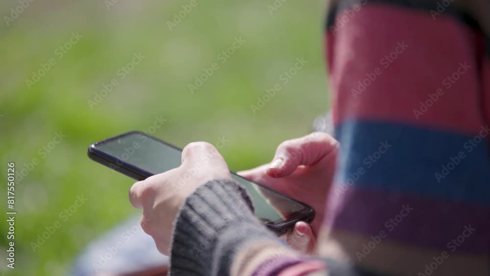 Mano de mujer usando teléfono celular al aire libre