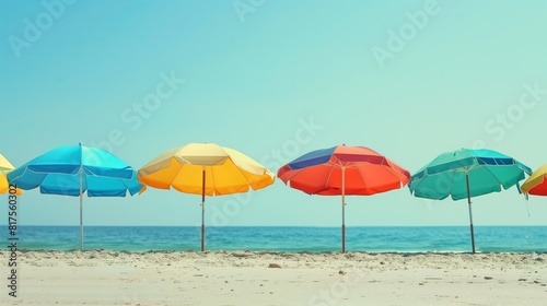 Vibrant beach umbrellas under sunshine cast shadows on sandy shore.