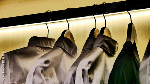 Close-up of elegant men's shirts hanging on the hangers in a wardrobe photo
