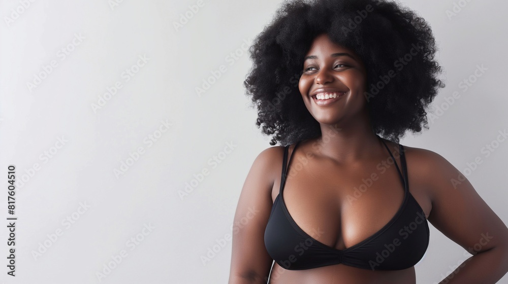 Confident plus size woman looking away with a cheerful smile while wearing underwear. Body positive woman with an Afro hairstyle, natural body and curly hair. body positive banner with copy space Confident plus size woman looking away with a cheerful smile while wearing underwear. Body positive woman with an Afro hairstyle, natural body and curly hair. body positive banner with copy space