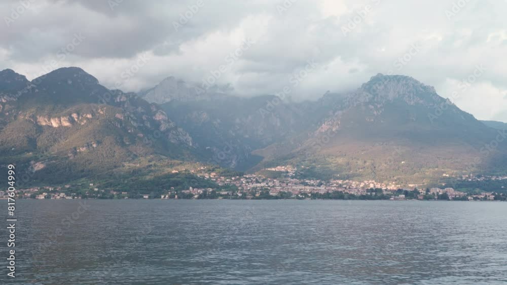 Mandello del Lario Town And Mountain Range Across The Lake Como In Lecco, Lombardy, Italy. - wide shot Mandello del Lario Town And Mountain Range Across The Lake Como In Lecco, Lombardy, Italy. - wide shot