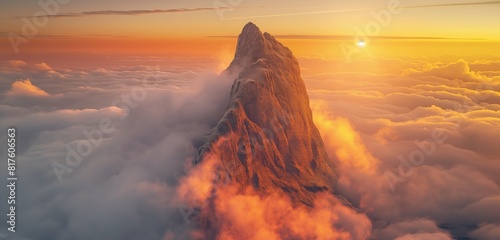 The summit of a towering mountain piercing through a blanket of clouds, the sun setting behind it and casting an orange glow on the mist. 32k, full ultra HD, high resolution photo
