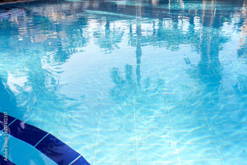 Azure liquid reflections of palm trees in a swimming pool create a tranquil natural landscape, perfect for leisure, recreation, and fun in the aqua fluid surroundings.