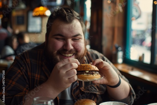 A joyful  overweight man savoring a burger in a lively caf    radiating contentment and enjoyment.