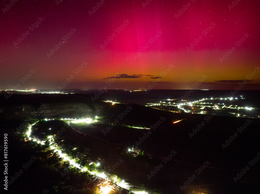 aerial view over orheiul vechi old orhei in butuceni historical place with church on cliff at night under bright rose green purple aurora borealis northern lights