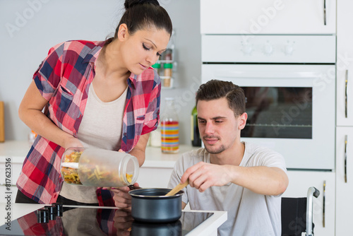 couple cooking together - man disabled on wheelchair photo