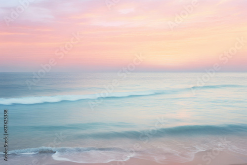 The photo shows a beautiful beach scene with a pink and blue sky and soft waves.