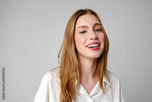 Joyful Young Blonde Woman Smiling against gray background