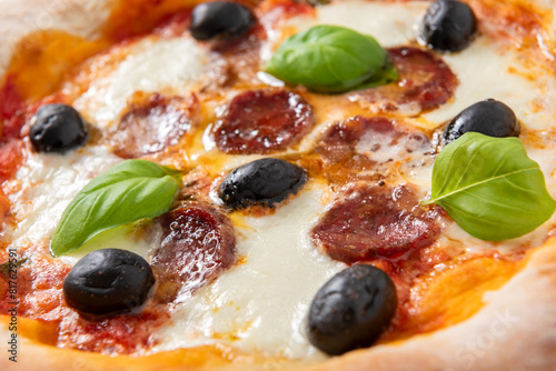 Deliziosa pizza italiana condita con mozzarella, sugo, salsiccia di maiale e olive nere, cibo italiano  photo