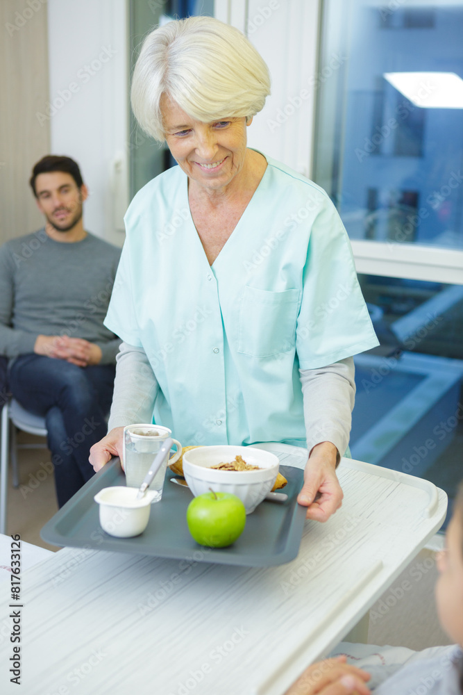 senior nurse holding breakfast tray for kid senior nurse holding breakfast tray for kid