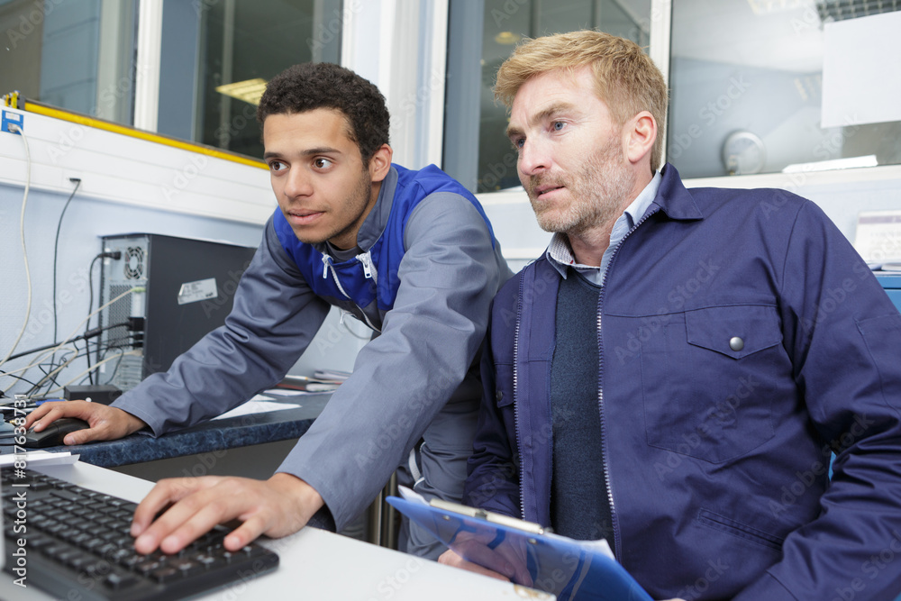 two men are holding computer two men are holding computer