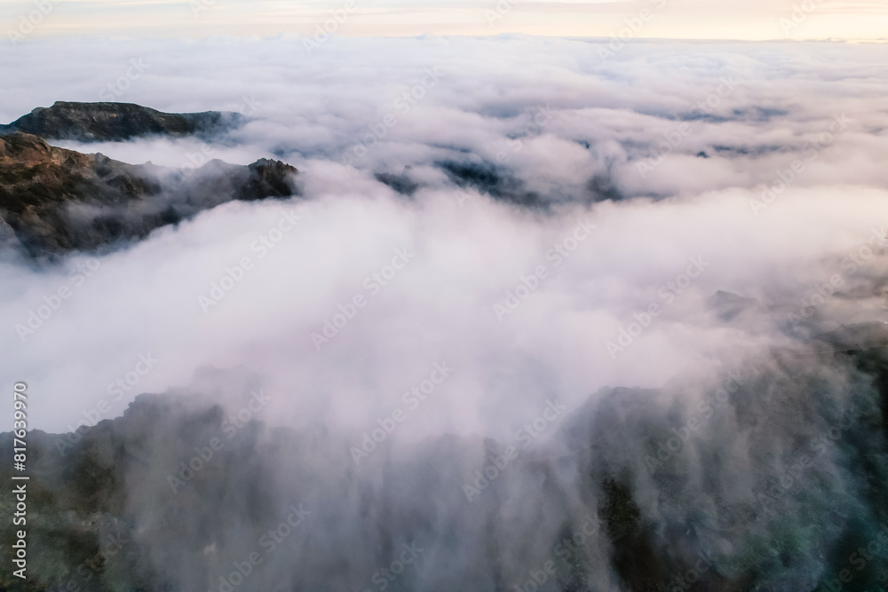Aerial view of majestic mountain ridges at sunrise with falling fog from top of Pico do Areeiro, Madeira island, Portugal Aerial view of majestic mountain ridges at sunrise with falling fog from top of Pico do Areeiro, Madeira island, Portugal