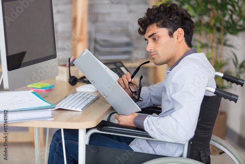 businessman sitting at desk in wheelchair