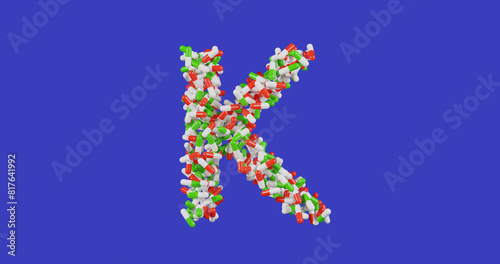 Vitamin K, pills in a red and white and green shell in the shape of the letter K isolated on a colored blue background, 3d rendering