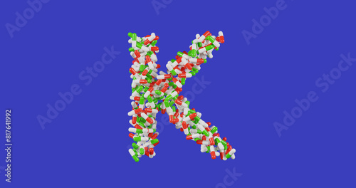 Photos Vitamin K, pills in a red and white and green shell in the shape of the letter K