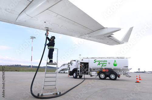 Technician is refueling aircraft with Sustainable Aviation Fuel (SAF) at the airport.