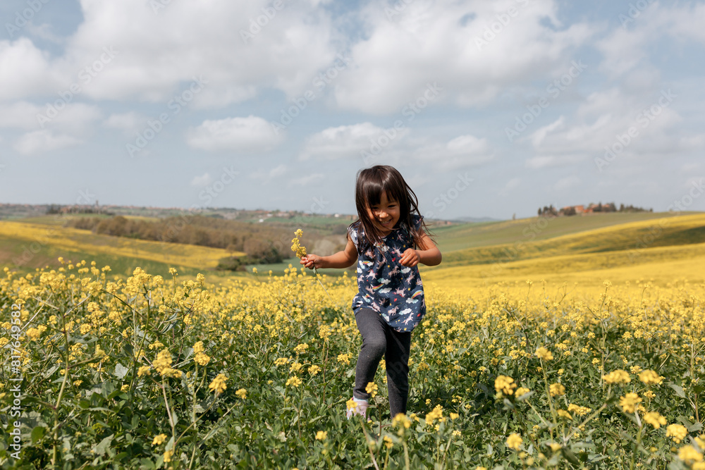 Running in a field of yellow flowers