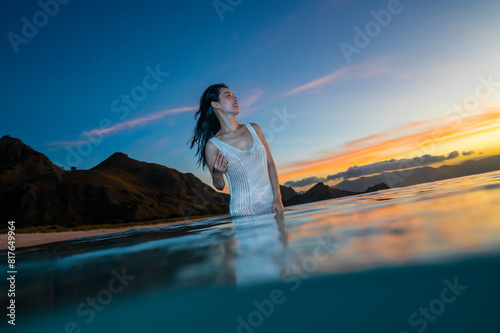 beautiful woman enjoying wading through the ocean in Komodo photo