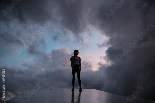 Girl stands silhouetted again passing storm photo