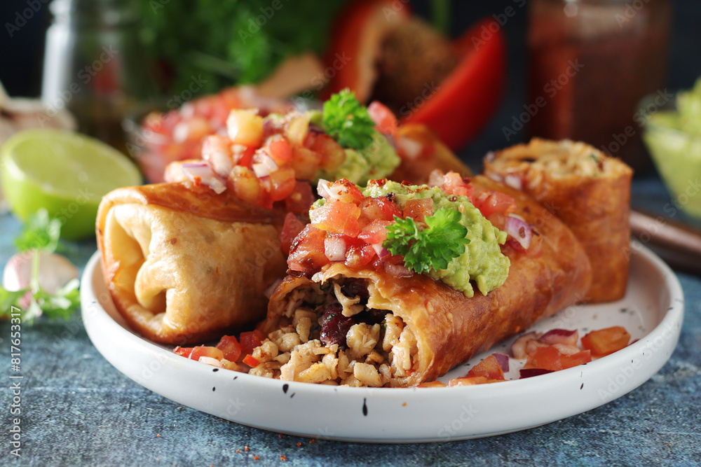 A typical dish of Mexican cuisine - Chimichanga, made of tortilla with different ingredients A typical dish of Mexican cuisine - Chimichanga, made of tortilla with different ingredients