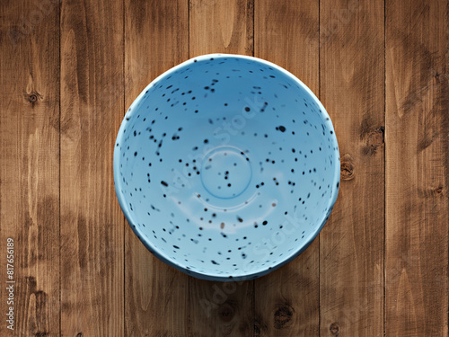 Top view of blue speckled bowl (3D rendering) on wooden table