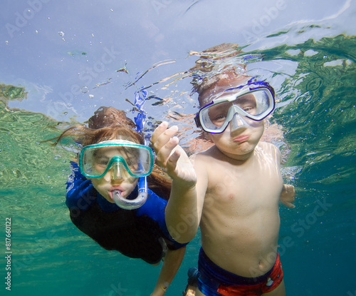 Pair of children snorkeling in clear sea water.
