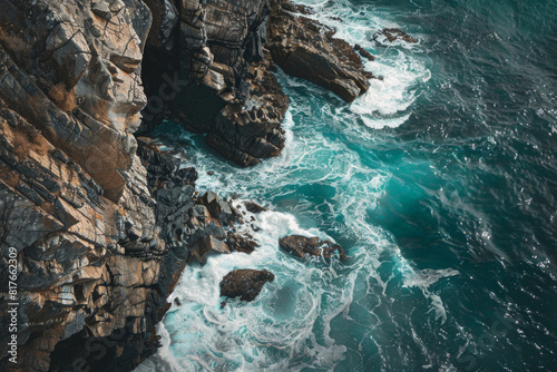 An aerial view of a rocky coastline, with waves crashing against the rugged cliffs, showcasing the contrast between smooth and rough textures. 