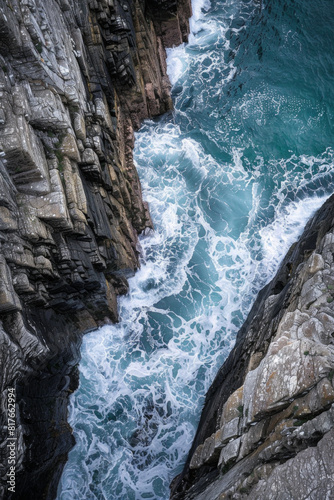 An aerial view of a rocky coastline, with waves crashing against the rugged cliffs, showcasing the contrast between smooth and rough textures. 