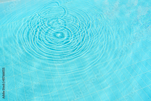 Top view of clear blue pool water with ripples, creating a serene and tranquil atmosphere.