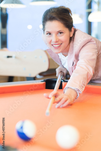 young beautiful smiling woman playing pool photo
