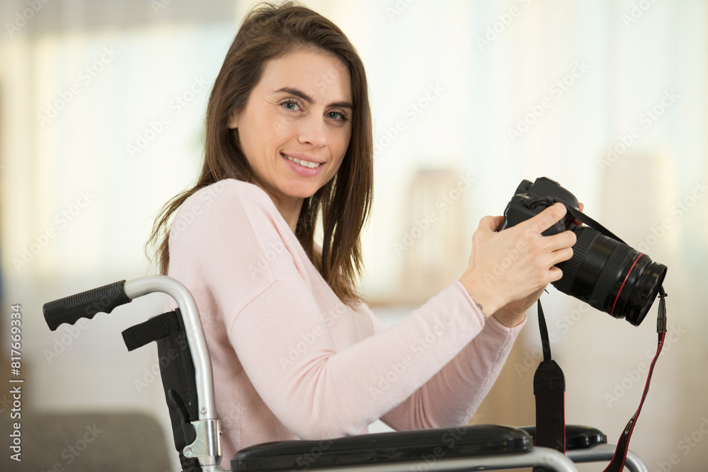 woman in wheelchair at home holding dslr camera woman in wheelchair at home holding dslr camera