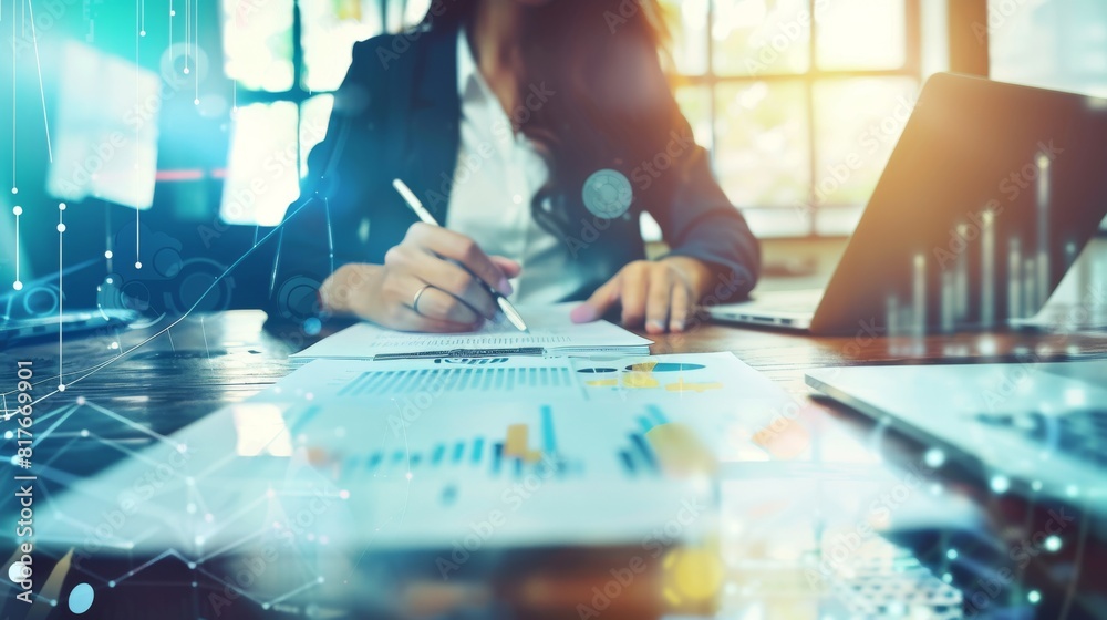 Image of a businesswoman at a desk assessing financial graphs with digital overlay Image of a businesswoman at a desk assessing financial graphs with digital overlay